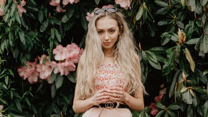 woman-standing-against-flowers-1500482-696x392